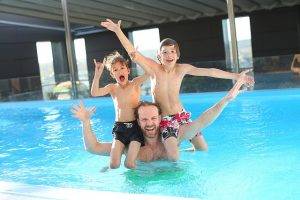 dad and two kids in the pool